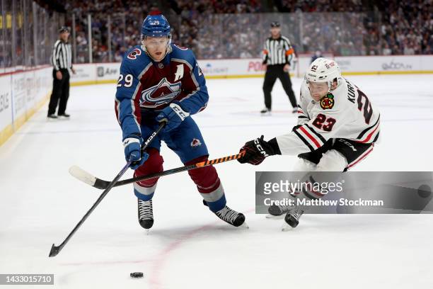 Nathan MacKinnon of the Colorado Avalanche races for the puck against Philipp Kurashev of the Chicago Blackhawks during the second period at Ball...