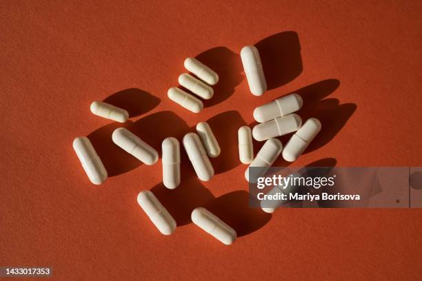 medicinal capsules on a terracotta background. - prozac stock pictures, royalty-free photos & images