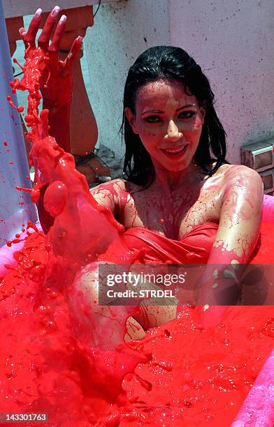 Indian Bollywood actress & model Rozlyn Khan bathes in a bath tub filled with red coloured water, as part of a protest against the use of animal...
