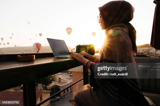 muslim  woman working on roof top cafe when traveling in cappadocia - hot middle eastern women stock pictures, royalty-free photos & images