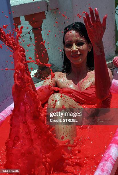 Indian Bollywood actress and model Rozlyn Khan bathes in a bath tub filled with red coloured water, as part of a protest against the use of animal...