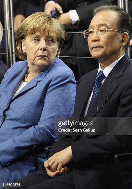 German Chancellor Angela Merkel eyes Chinese Premier Wen Jiabao during a signing of agreements between Volkswagen and Chinese companies at the...