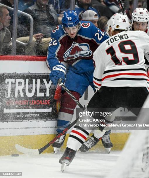 Lukas Sedlak of the Colorado Avalanche gets checked by Alec Regula of the Chicago Blackhawks during the second period at Ball Arena in Denver on...