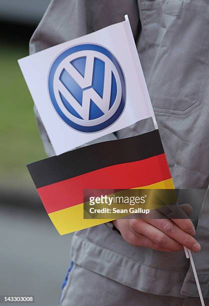 Workers hold German and Volkswagen logo flags before the arrival of Chinese Premier Wen Jiabao next at the Volkswagen factory on April 23, 2012 in...