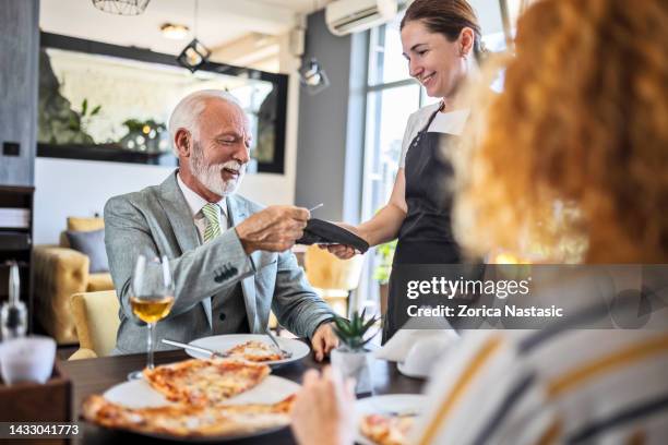 father having pizza with daughter in restaurant ,paying bill - paying for dinner imagens e fotografias de stock