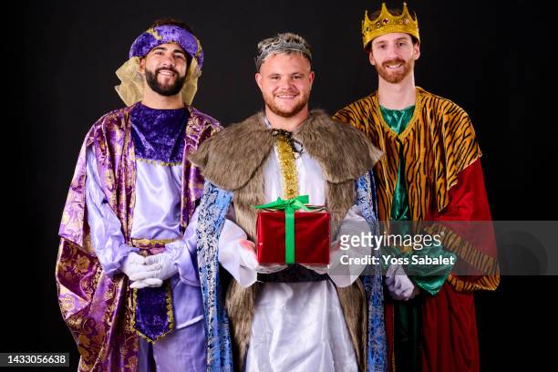 the three kings with a christmas present - 3 kings stock-fotos und bilder