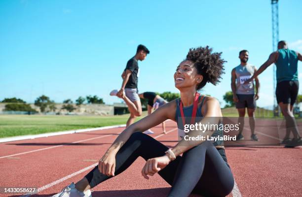 atletica, sport e donna stanca dopo l'allenamento con la squadra con medaglia allo stadio insieme. atleta felice, entusiasta e giovane corridore che pensa al successo nella corsa sul campo per la competizione professionale - atleta di atletica leggera foto e immagini stock