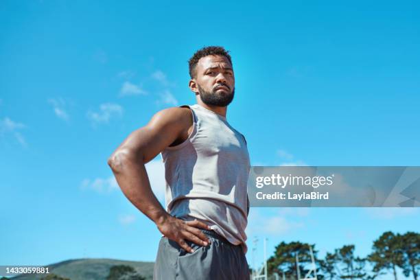 fitness, black man and serious about exercise, health and wellness outside in blue sky nature for run, hike or cardio workout.  portrait of athletic guy take break from exercising or training outdoor - arms akimbo stock pictures, royalty-free photos & images