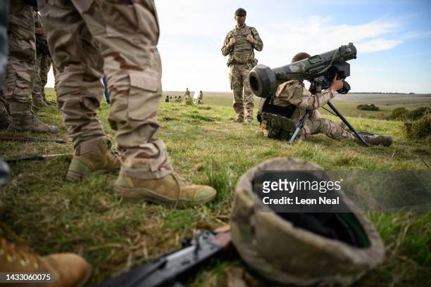 Ukrainian recruit looks through the viewfinder of a FGM-148 Javelin surface-to-air missile as a British instructor looks on, during a field training...