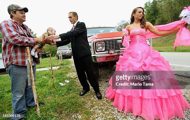 Dates Coty Shouse and Destiny Duff gather as Destiny's father Ronnie Duff passes a baby to be photographed while preparing for the Owsley County High...