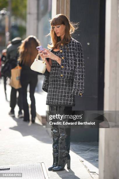 Guest wears a black with white checkered embroidered pattern tweed short dress, a matching black with white checkered embroidered pattern tweed...