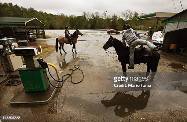 Horse riders prepare to depart after a break at a gas station during the Owsley County Saddle Club trail ride on April 21, 2012 in Booneville,...