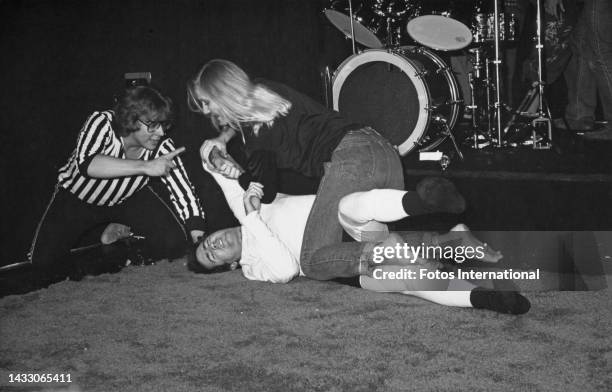 American comedian Andy Kaufman is pinned to the mat by Elizabeth Hocker during a wrestling match as a referee gives the count, at the Comedy Store...
