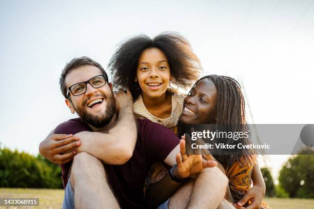 ritratto di una famiglia multirazziale che si diverte all'aperto - mixed race person foto e immagini stock