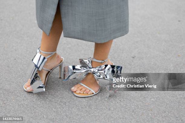 Guest wears silver Loewe heels with bow tie outside Zimmermann during Paris Fashion Week - Womenswear Spring/Summer 2023 : Day Eight on October 03,...