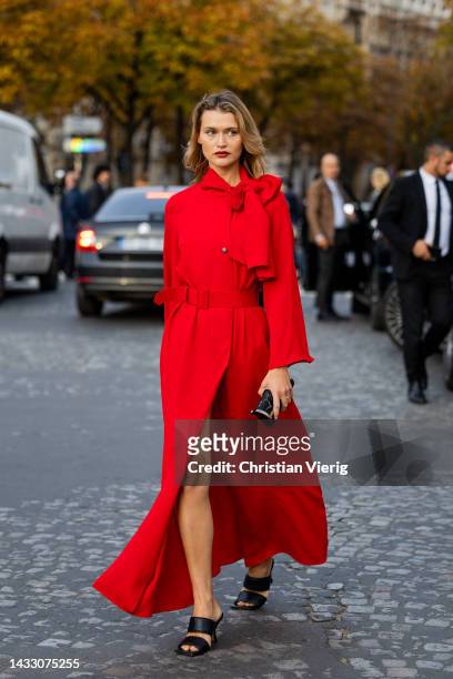 Chloe Lecareux wears red belted dress, black bag outside Rokh during Paris Fashion Week - Womenswear Spring/Summer 2023 : Day Eight on October 03,...