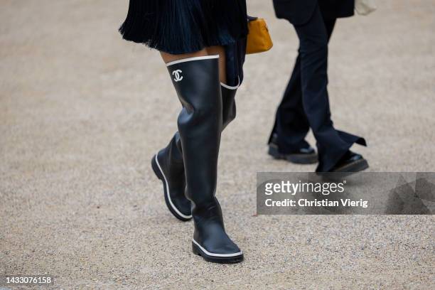 Guest wears black Chanel rain boots outside Zimmermann during Paris Fashion Week - Womenswear Spring/Summer 2023 : Day Eight on October 03, 2022 in...
