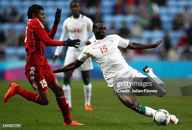 Ibrahima Seck of Senegal tackles Raed Saleh of Oman during the London 2012 Olympic Qualifier match between Senegal and Oman at the Ricoh Arena on...