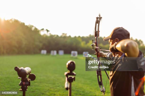 man with prosthetic arm practicing archery outdoors - archery range bildbanksfoton och bilder