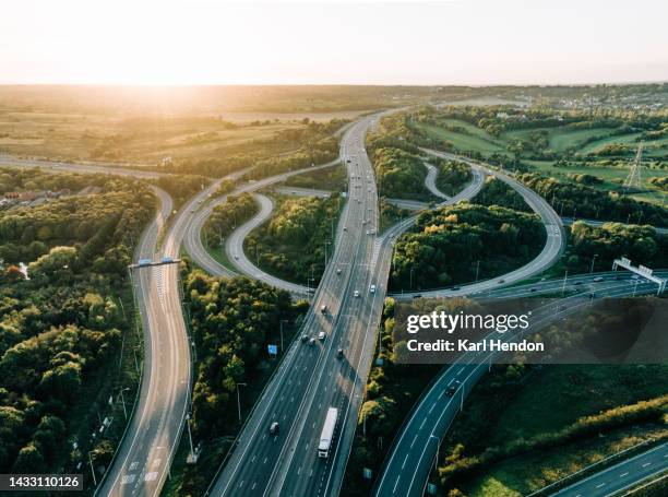 an aerial sunset view of a multi-lane road intersection in the uk - straßenüberführung stock-fotos und bilder