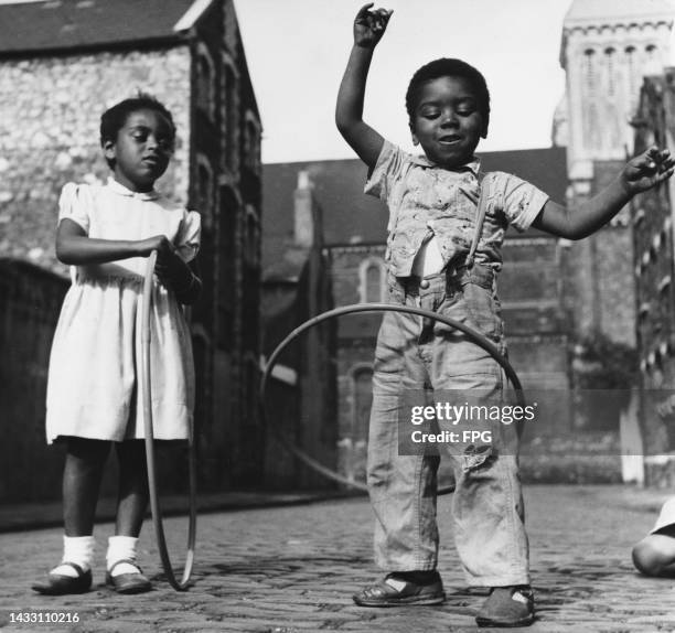 Anthony Campbell, three, hula-hooping as his sister Elaine, five, watches in Cardiff on October 10th, 1958.