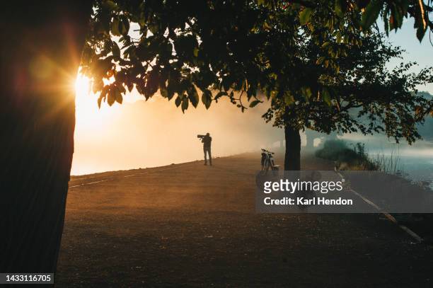 photographer. autumn sunrise in a london park - richmond upon thames stockfoto's en -beelden