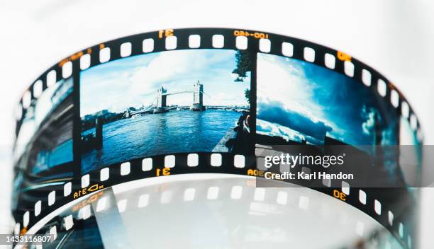 a film strip of london images on a table - fotorolletje stockfoto's en -beelden