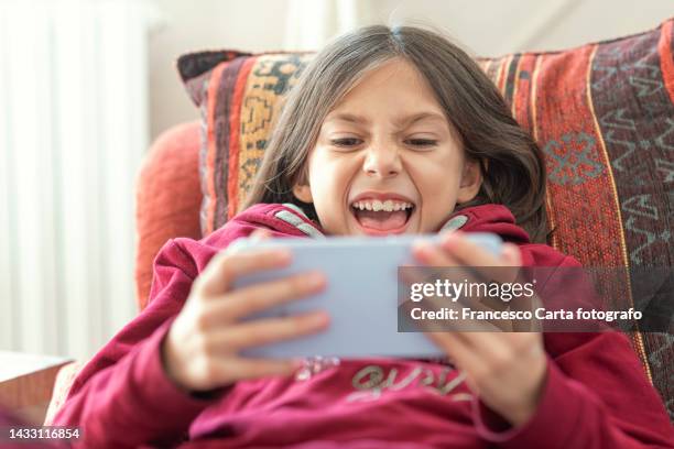 excited girl playing with a smartphone - child using a smartphone stock pictures, royalty-free photos & images