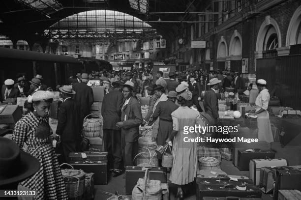 West Indian immigrants arrive at Victoria Station, London, after their journey from Southampton Docks. Original Publication: Picture Post - 8405 -...