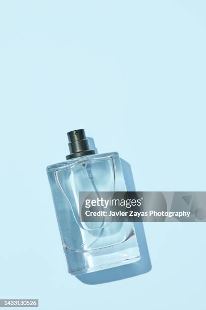 liquid sprayer on blue background - aftershave bottle stock-fotos und bilder
