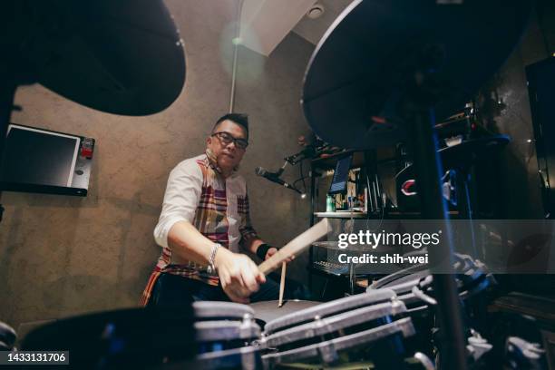 middle-aged asian man playing drum set on recording studio - drummer stock pictures, royalty-free photos & images