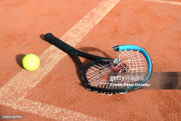 broken tennis racket on clay court - hat rack bildbanksfoton och bilder