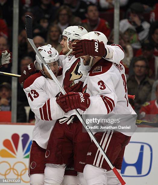 Ray Whitney and Keith Yandle of the Phoenix Coyotes hug teammate Oliver Ekman-Larsson after Larsson scored a second period goal against the Chicago...