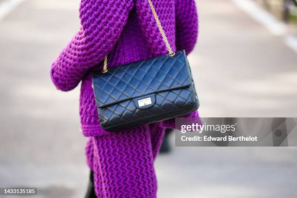 Guest wears a purple wool buttoned cardigan from Chanel, a matching purple wool knees skirt from Chanel, a black shiny leather 2.55 shoulder bag from...