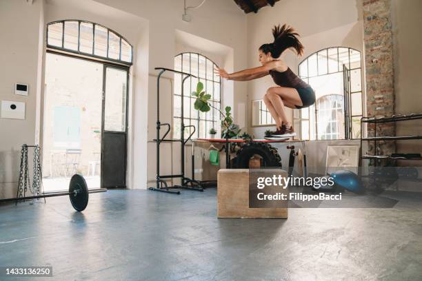 eine junge erwachsene frau trainiert im health club - hiit stock-fotos und bilder