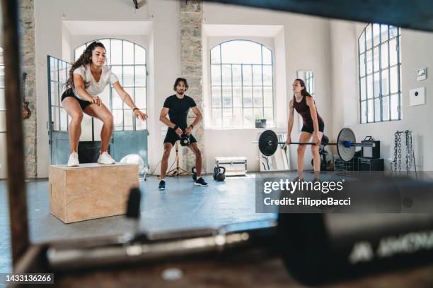 people doing cross training in an health club - crossfit stockfoto's en -beelden