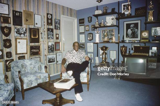 Portrait of Jesse Owens of the United States, quadruple Olympic gold medallist at the 1936 Olympic Games in Berlin at home surround by his winning...