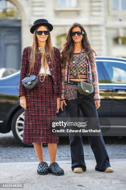 Carlotta Oddi wears a black tweed hat, black sunglasses, gold earrings, a gold chain with large pendant necklace from Chanel, a red and black...