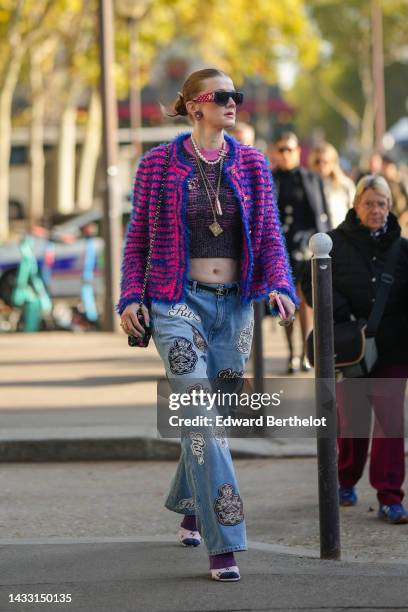 Guest wears purple pink sunglasses from Chanel, purple earrings, a white pearls / silver chain long necklace from Chanel, a black and pink wool...