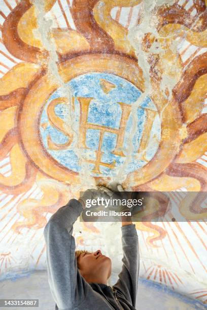 professional restorer restoring antique chapel fresco in italy - restoring art stock pictures, royalty-free photos & images