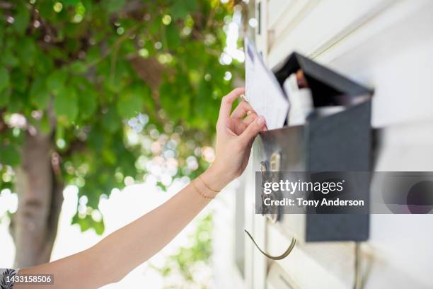 close view of arm reaching for mail - mailbox fotografías e imágenes de stock