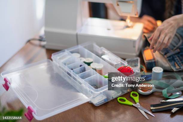 view of hands of woman using sewing machine focus on sewing supplies - nähset stock-fotos und bilder