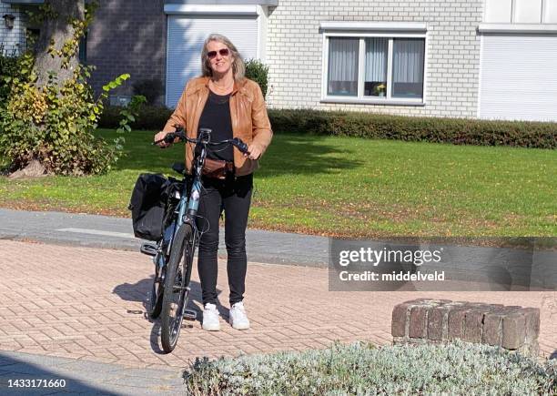 frau, die mit dem e-bike ankommt - shopping with bike stock-fotos und bilder