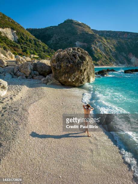 young woman bathing in beautiful paralia petani beach with turquoise sea in kefalonia, greece - white bay stock pictures, royalty-free photos & images