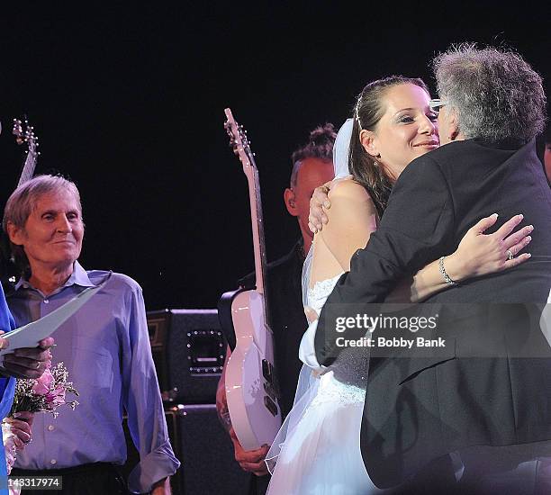 Levon Helm looks on while, Jenni Maurer West and Leslie West of Mountain get married onstage during Heros of Woodstock Tour on the 40th anniversary...