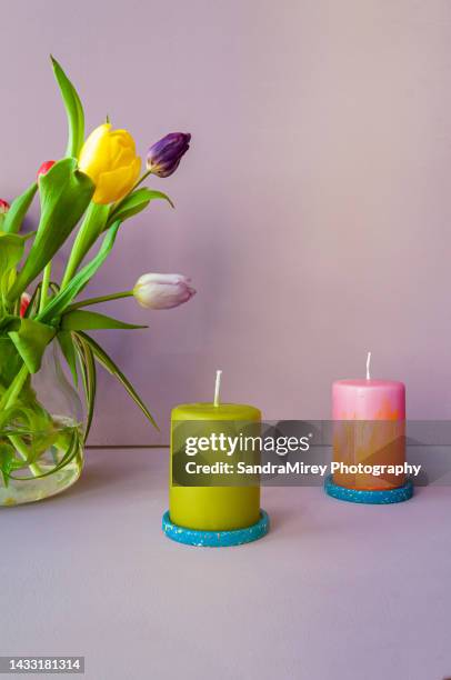 modern home decor scene, memphis style. terrazzo coaster with colorful pillar candles with dutch tulips - terrazzo stock pictures, royalty-free photos & images