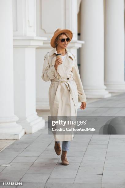 smiling young woman - trenchcoat stockfoto's en -beelden