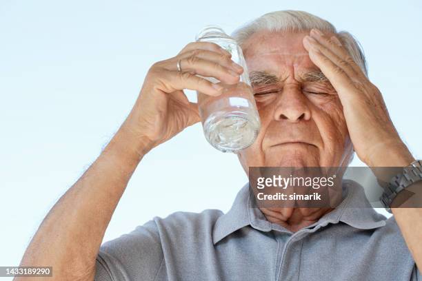senior man trying to cool down - hyperthermia stockfoto's en -beelden