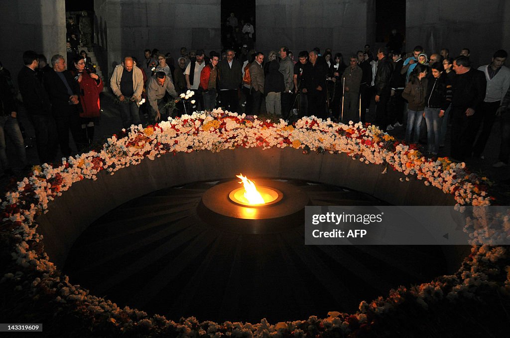 Armenians lay candles and flowers at the