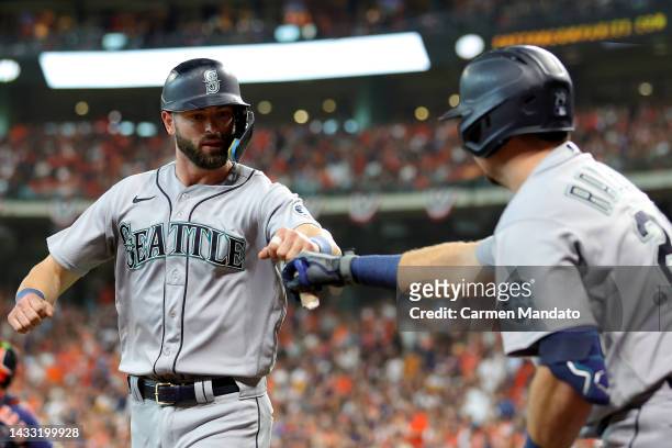 Mitch Haniger of the Seattle Mariners fist bunps Cal Raleigh after scoring a run against the Houston Astros during the fourth inning in game two of...